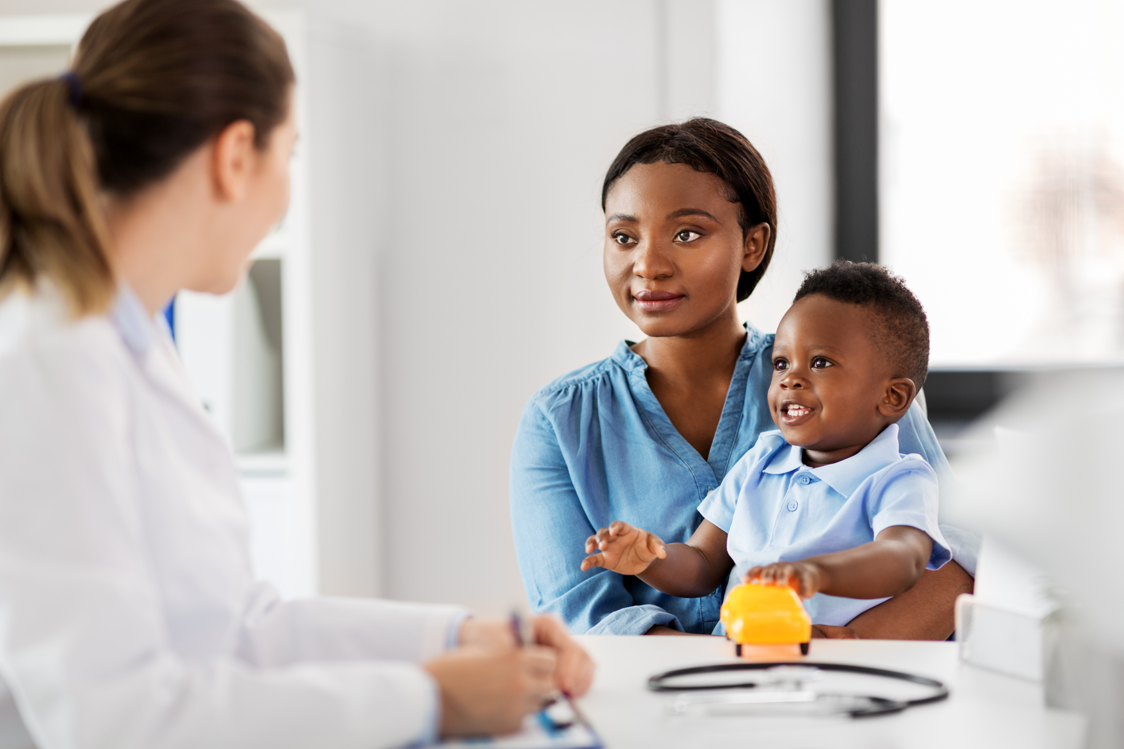 Happy Mother with Baby Son at Doctor's Clinic